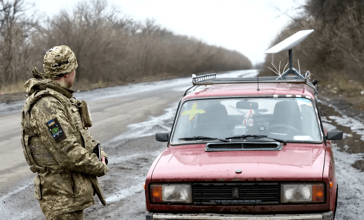 Фото: украинский военнослужащий стоит рядом с автомобилем, на котором установлен терминал спутниковой связи Starlink / Reuters
